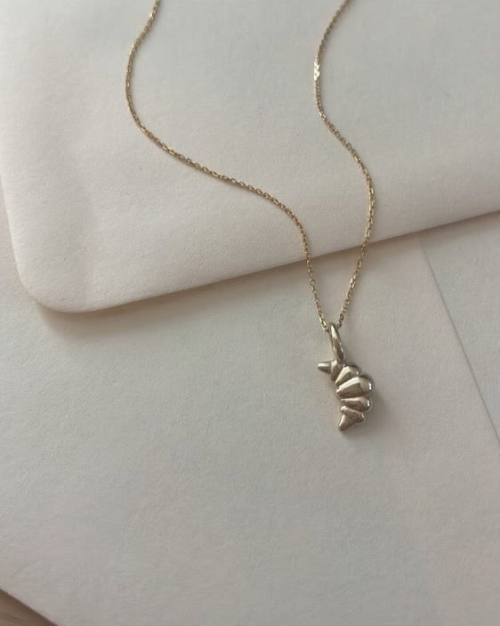 Croissant Pendant made out of 14k yellow gold strung on a golden chain